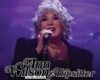 Female singer on stage with a microphone under purple lighting; logo reads 'Ann Wilson & Tipster' at the bottom.